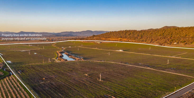 Rogue Valley Irrigated Farm with 302.22 Acres of Water Rights seen from the air, with low mountains in the background